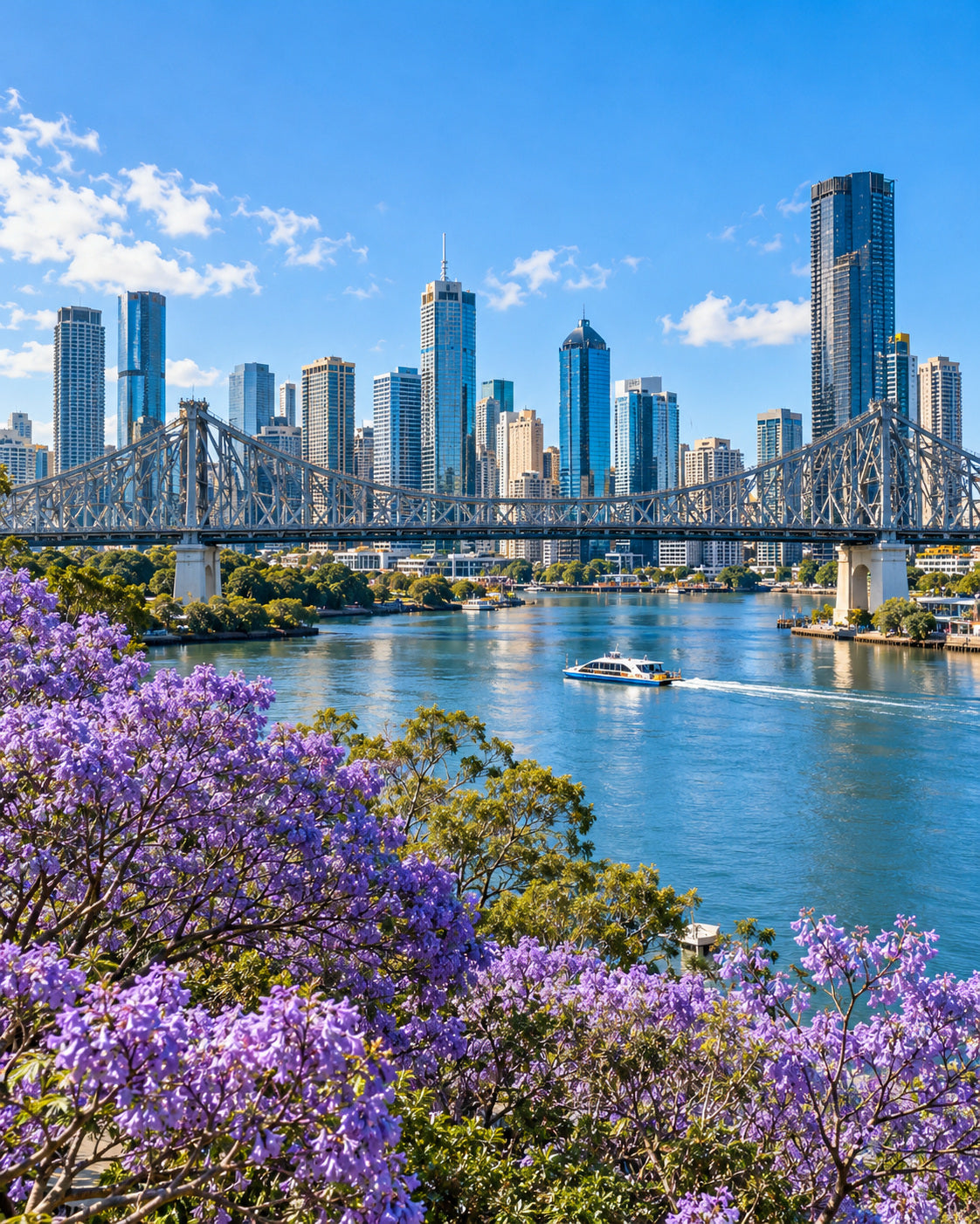 Brisbane: Story Bridge über dem blauen Fluss mit Brisbanes Skyline und blühenden Jacarandabäumen