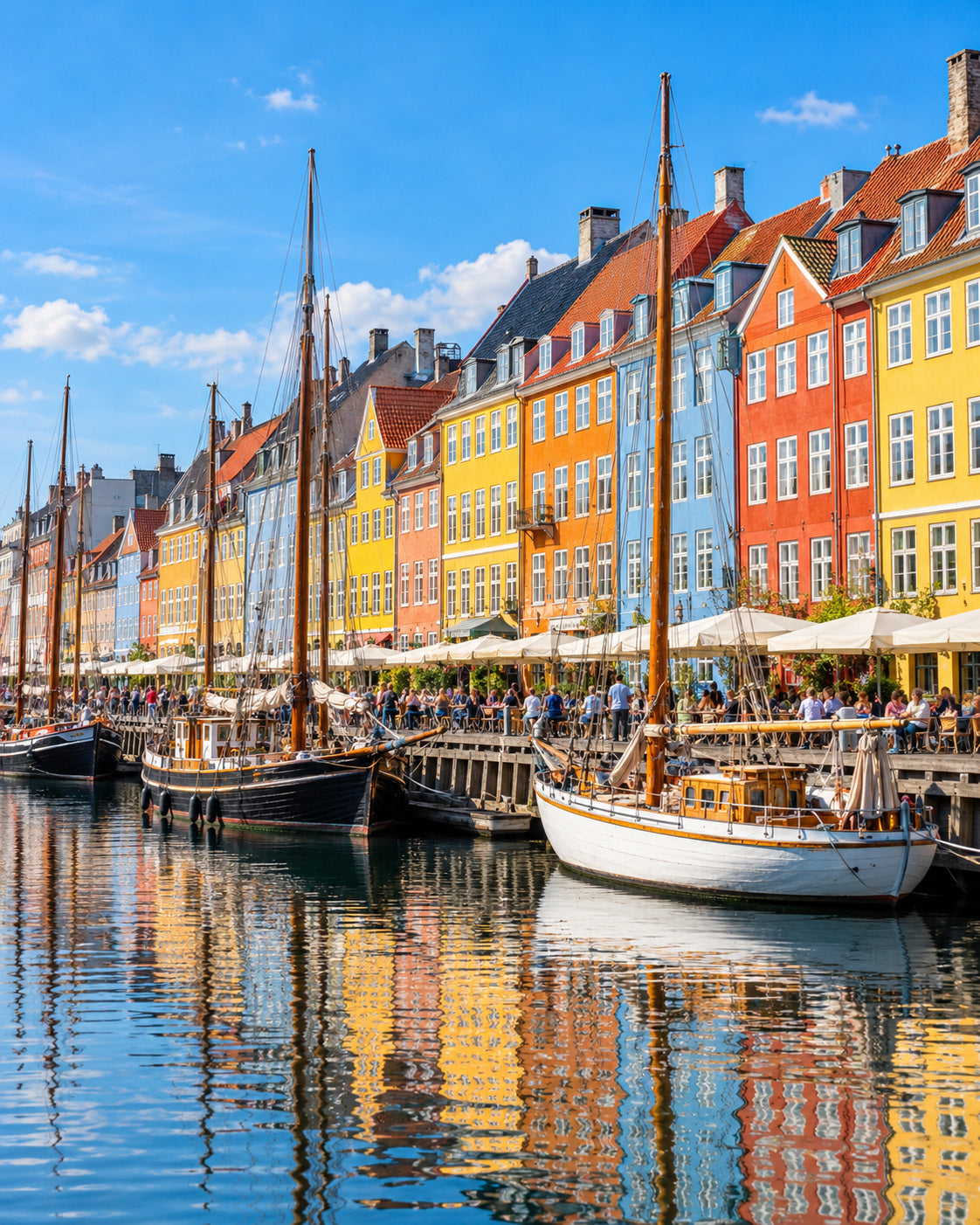 Copenhague: casas de colores de Nyhavn y antiguos veleros reflejados en el canal bajo el sol