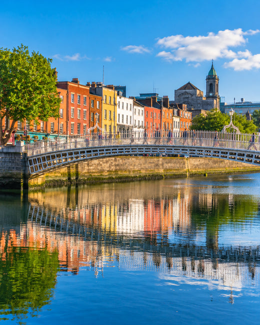 Dublin: Ha'penny Bridge über der Liffey mit bunten georgianischen Uferfassaden im Sonnenschein