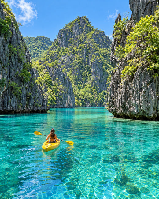 El Nido: türkisfarbene Big Lagoon zwischen bewaldeten Kalksteinfelsen mit einem kleinen Kajak