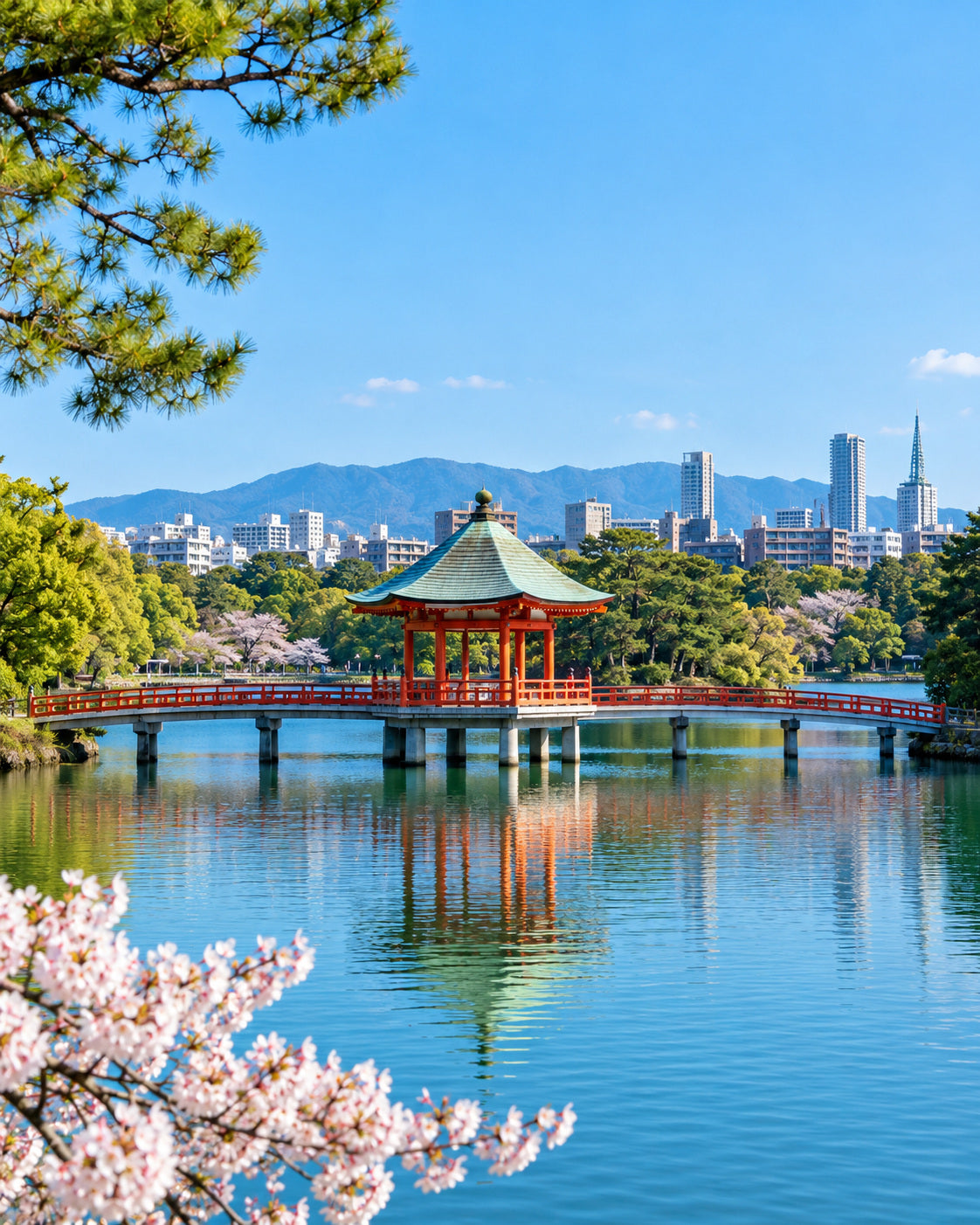 Fukuoka: See im Ohori-Park mit rotem Pavillon, Bogenbrücken und grünen Bäumen unter blauem Himmel