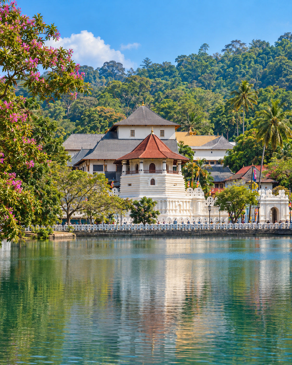 Kandy: temple of the Sacred Tooth Relic beside Kandy Lake, tiled roofs, white walls and green hills