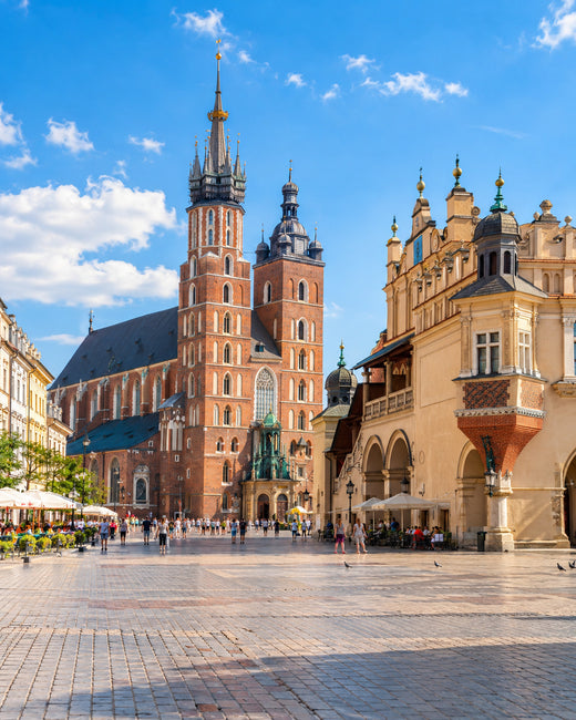 Krakau: Hauptmarkt in Krakau mit Marienkirche, Tuchhallen und bunten Fassaden unter blauem Himmel
