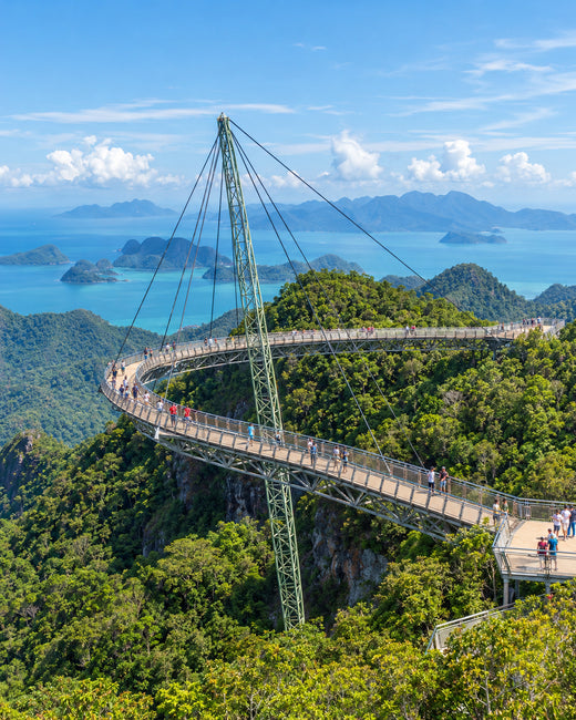 Langkawi: geschwungene Langkawi Sky Bridge über grünem Wald mit der Andamanensee im Hintergrund