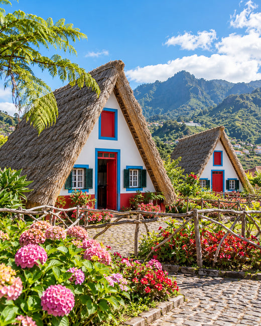 Madeira: traditionelle strohgedeckte Häuser in Santana mit roten Türen, blauen Einfassungen und grünen Gärten