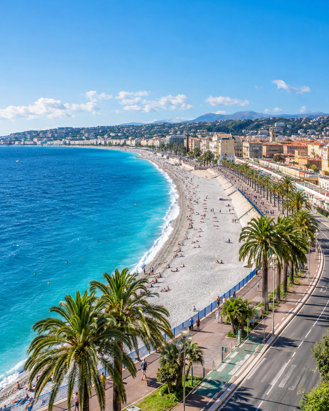 Nice: nice Promenade des Anglais curving beside azure sea, pastel buildings, palms and clear sunny sky