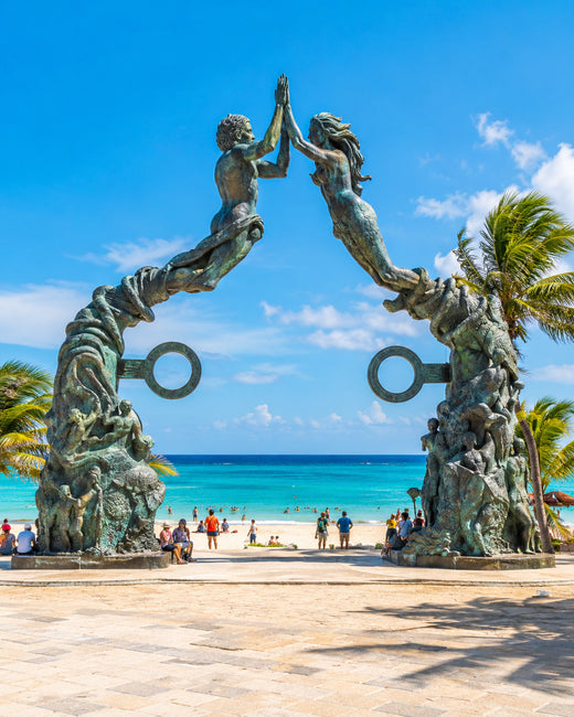 Playa del Carmen: Portal-Maya-Skulptur im Parque Fundadores neben weißem Sand und türkisfarbenem Karibikwasser