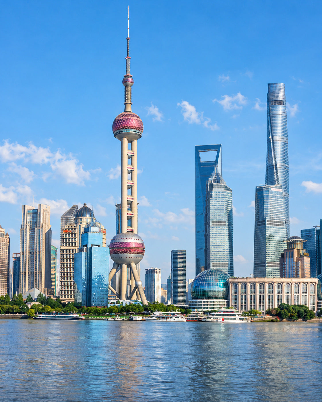 Shanghai: pudong skyline with Oriental Pearl Tower and Shanghai Tower seen across the Huangpu River in bright daylight