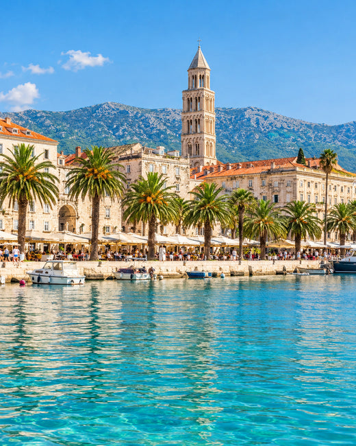 Split: palmengesäumte Riva mit Steinfassaden des Diokletianpalasts und türkisfarbener Adria