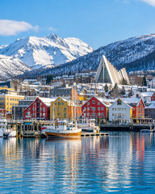 Tromsø: bunter Hafen von Tromsø mit verschneiten Bergen und Eismeerkathedrale im hellen Winterlicht